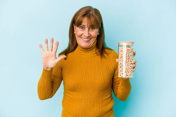 Middle Age Caucasian Woman Holding Chickpea Jar Isolated Blue Background — Fotografia de Stock