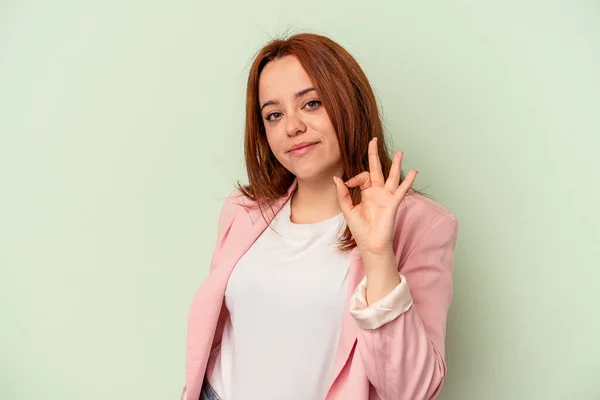 Mulher Branca Jovem Isolado Fundo Verde Pisca Olho Mantém Gesto — Fotografia de Stock