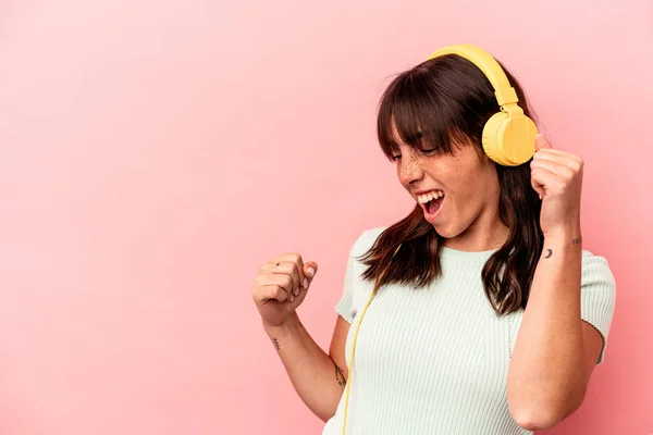 Νεαρή Αργεντίνισσα Που Ακούει Μουσική Απομονωμένη Ροζ Φόντο Υψώνοντας Γροθιά — Φωτογραφία Αρχείου