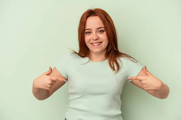 Mujer Joven Caucásica Aislada Sobre Fondo Verde Apunta Hacia Abajo — Foto de Stock