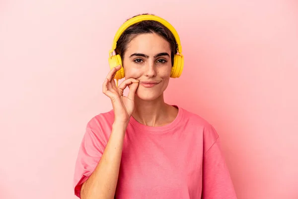 Young Caucasian Woman Listening Music Isolated Pink Background Fingers Lips — Stock Photo, Image