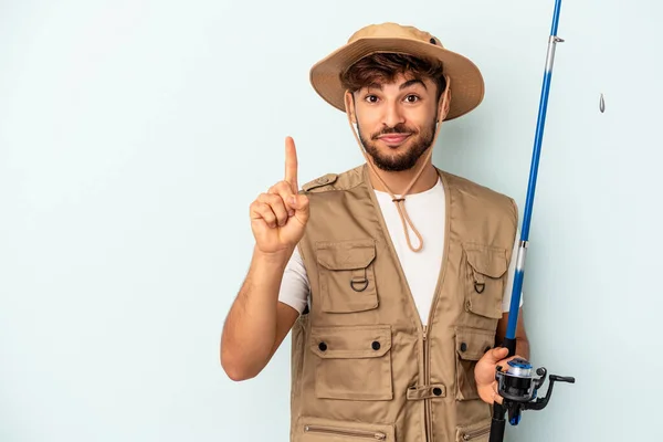 Young Mixed Race Fisherman Holding Rod Isolated Blue Background Showing — 图库照片