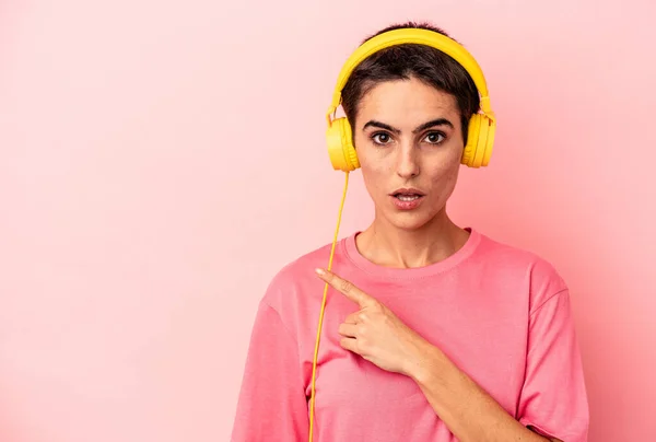 Jonge Kaukasische Vrouw Luisteren Naar Muziek Geïsoleerd Roze Achtergrond Wijzen — Stockfoto