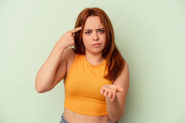 Mujer Joven Caucásica Aislada Sobre Fondo Verde Sosteniendo Mostrando Producto —  Fotos de Stock