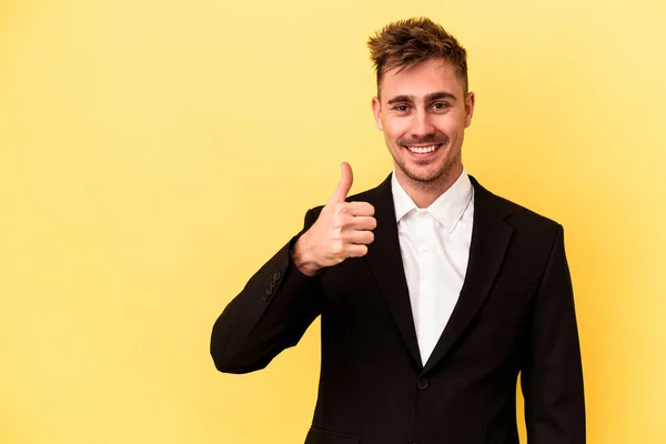 Νεαρός Καυκάσιος Επιχειρηματίας Απομονωμένος Κίτρινο Φόντο Χαμογελώντας Και Υψώνοντας Τον — Φωτογραφία Αρχείου