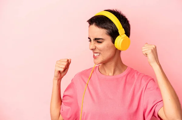 Young Caucasian Woman Listening Music Isolated Pink Background Raising Fist — Φωτογραφία Αρχείου