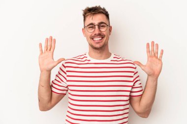 Beyaz arka planda izole edilmiş beyaz tenli genç adam on numarayı elleriyle gösteriyor..
