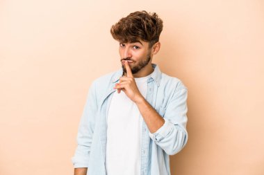 Genç Arap adam bej arka planda izole edilmiş. Bir strateji planlıyor, bir iş yolu düşünüyor..