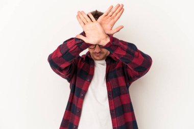 Beyaz arka planda izole genç beyaz adam iki kolu çapraz tutuyor, inkar kavramı.