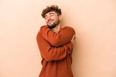 Genç Arap adam bej arka planda yalnızdı. Sarılmalar, kaygısız gülümsemeler ve mutluluklar..