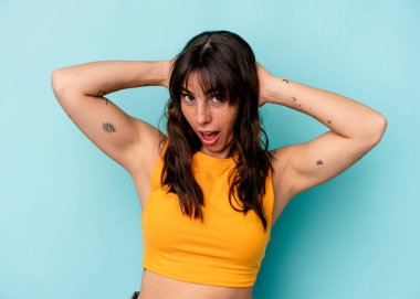 Genç Arjantinli kadın mavi arka planda izole edilmiş bağırıyor, çok heyecanlı, tutkulu, bir şeyden memnun..