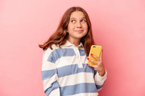 Menina Caucasiana Segurando Telefone Celular Isolado Fundo Rosa Sonhando Alcançar — Fotografia de Stock