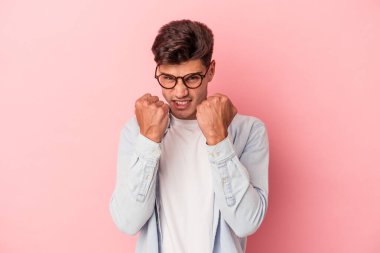 Pembe arka planda izole edilmiş genç beyaz bir adam bir tartışma yüzünden yumruk, öfke, kavga ve boks atıyor..