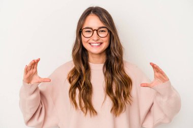 Beyaz arka planda izole edilmiş beyaz bir kadın elinde avuç içi bir şeyle kameraya sunuyor..