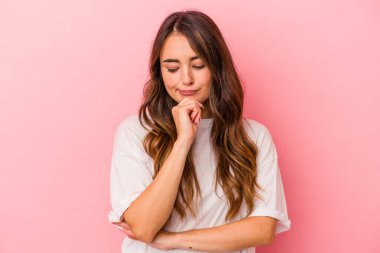 Pembe arka planda soyutlanmış beyaz bir kadın şüpheli ve şüpheci bir ifadeyle yana bakıyor..