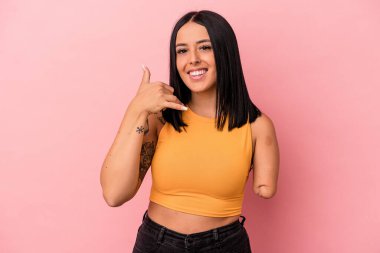 Tek kollu beyaz bir kadın pembe arka planda izole edilmiş. Cep telefonu hareketini parmaklarıyla gösteriyor..