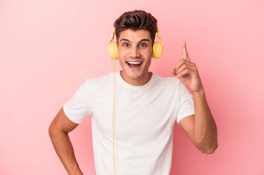 Pembe arka planda izole edilmiş müzik dinleyen beyaz bir adamın bir fikri, ilham konsepti var..
