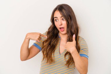 Beyaz arka planda izole edilmiş genç beyaz bir kadın parmağını göstererek şaşırdı, geniş bir gülümsemeyle..