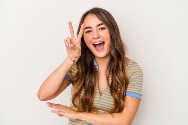 Beyaz arka planda izole edilmiş genç beyaz kadın iki numarayı parmaklarıyla gösteriyor..