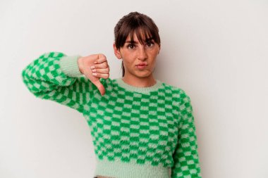 Beyaz arka planda izole edilmiş genç Arjantinli kadın baş parmağını aşağı gösteriyor, hayal kırıklığı konsepti.