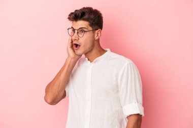 Pembe arka planda izole edilmiş genç beyaz adam gördüğü bir şey yüzünden şoka uğruyor..