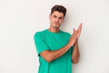 Beyaz arka planda izole olmuş genç beyaz bir adam enerjik ve rahat hissediyor, ellerini ovuşturuyor..