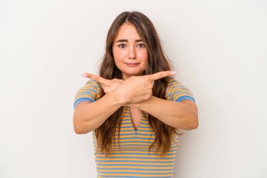 Beyaz arka plan noktalarında izole genç beyaz kadın, iki seçenek arasında seçim yapmaya çalışıyor.