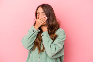 Pembe arka planda izole edilmiş genç beyaz kadın virüs veya enfeksiyon yüzünden boğazında ağrı hissediyor..