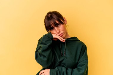 Sarı arka planda izole edilmiş genç Arjantinli kadın tekrarlanan bir görevden yoruldu.