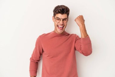 Beyaz arka planda izole edilmiş genç beyaz adam tasasız ve heyecanlı bir şekilde tezahürat yapıyor. Zafer konsepti.