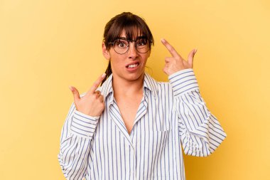 Sarı arka planda izole edilmiş genç Arjantinli kadın işaret parmağıyla hayal kırıklığı gösteriyor..