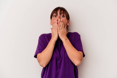 Beyaz arka planda izole edilmiş genç Arjantinli kadın elleriyle ağzını kapatırken şok oldu..