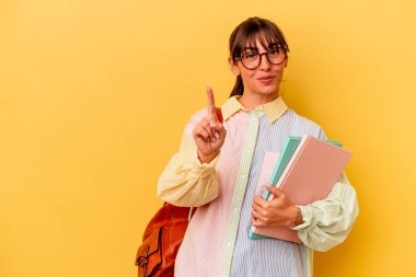 Arjantinli genç bir öğrenci sarı arka planda izole edilmiş. Parmak izleriyle bir numara..