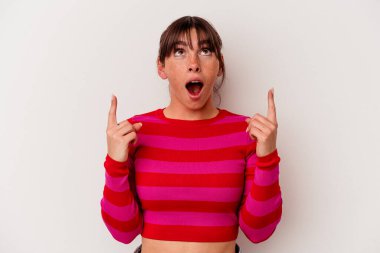Beyaz arka planda izole edilmiş genç Arjantinli kadın ağzı açık bir şekilde üst tarafı işaret ediyor..