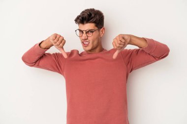 Beyaz arka planda izole edilmiş genç beyaz adam baş parmağını aşağı gösteriyor, hayal kırıklığı konsepti..