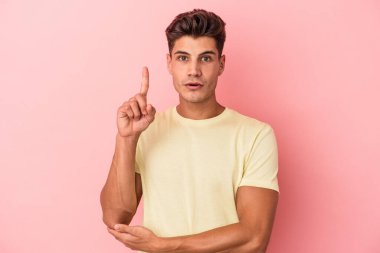 Pembe arka planda soyutlanmış genç beyaz bir adam. Harika bir fikri var, yaratıcılık kavramı..