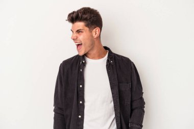 Beyaz arka planda izole genç beyaz adam çok kızgın, öfke kavramı bağırıyor, hayal kırıklığına uğramış.