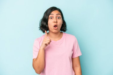 Mavi arka planda soyutlanmış genç Latin bir kadının bir fikri, ilham konsepti var..