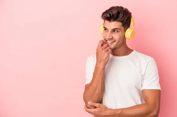 Jonge Blanke Man Luisteren Naar Muziek Geïsoleerd Roze Achtergrond Ontspannen — Stockfoto