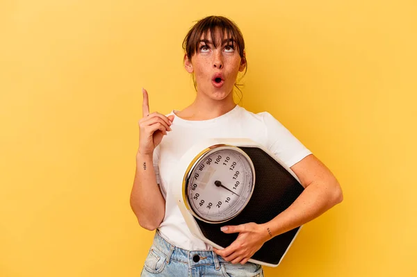 Jonge Vrouw Met Een Schaal Geïsoleerd Gele Achtergrond Wijzen Naar — Stockfoto