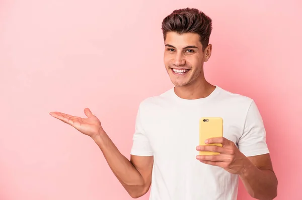 Młody Kaukaski Mężczyzna Trzymając Telefon Komórkowy Odizolowany Różowym Tle Ukazujący — Zdjęcie stockowe