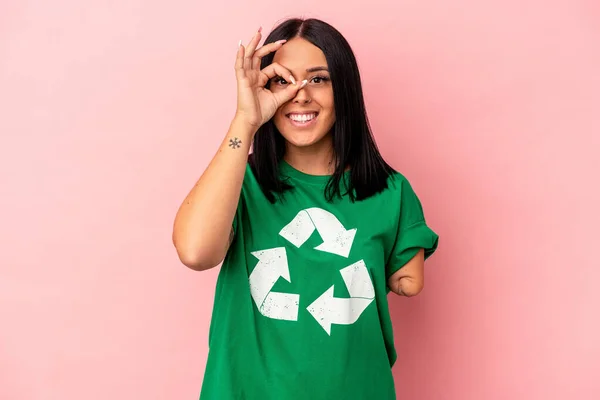 若いですCaucasian女性とともに一本の腕リサイクル廃棄物隔離上のピンクの背景励起保つOkジェスチャー上の目 — ストック写真