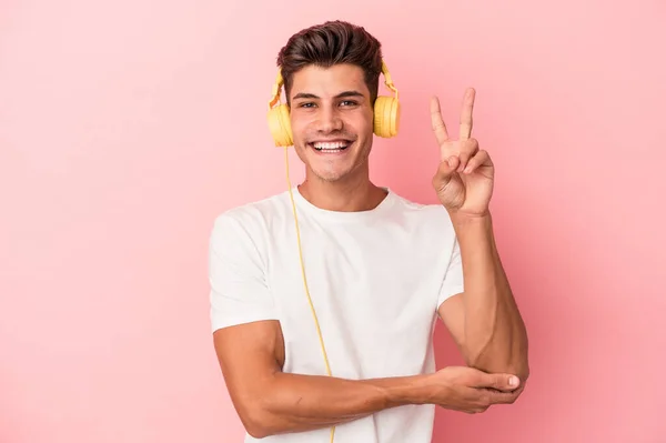 Jonge Kaukasische Man Luisteren Naar Muziek Geïsoleerd Roze Achtergrond Tonen — Stockfoto