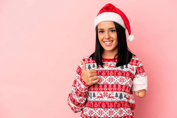 若いですCaucasian女性ともに一つの腕お祝いクリスマス隔離上のピンクの背景笑顔と上げ親指アップ — ストック写真
