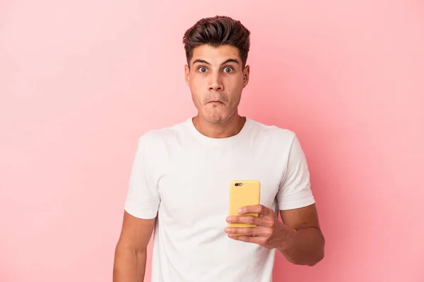 Młody Biały Mężczyzna Trzymając Telefon Komórkowy Odizolowany Różowym Tle Wzrusza — Zdjęcie stockowe
