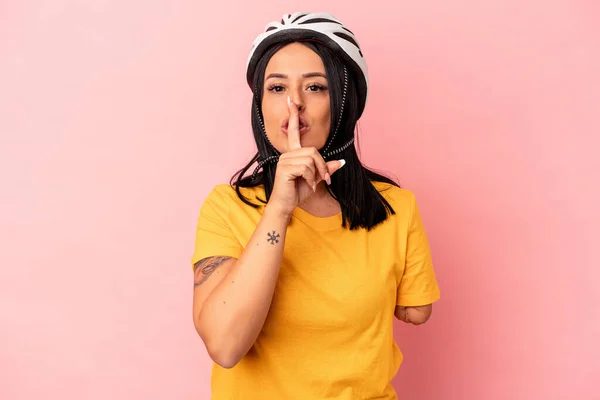 ピンクの背景に隔離された自転車のヘルメットを身に着けている1本の腕を持つ若い白人女性は 秘密を保持するか 沈黙を求めて — ストック写真