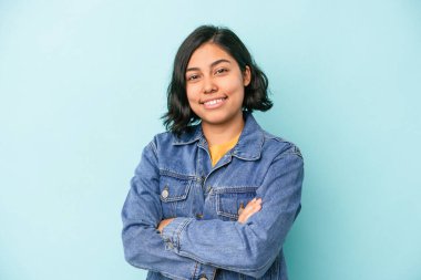 Mavi arka planda izole edilmiş genç Latin kadın mutlu, güler yüzlü ve neşeli..