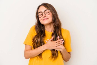 Beyaz arka planda izole edilmiş beyaz tenli genç bir kadın, dostane bir ifadeye sahip, avuçlarını göğsüne bastırıyor. Aşk konsepti.