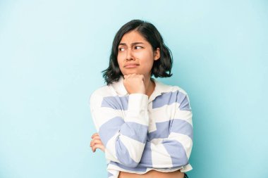 Mavi arka planda izole edilmiş genç Latin kadın virüs ya da enfeksiyon yüzünden boğaz ağrısı çekiyor..