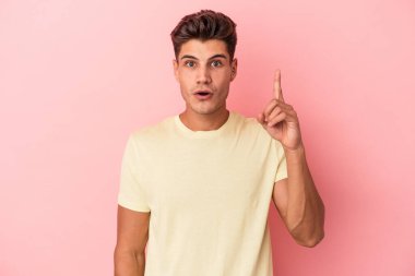 Pembe arka planda soyutlanmış genç beyaz bir adamın bir fikri var, ilham verici bir kavram..